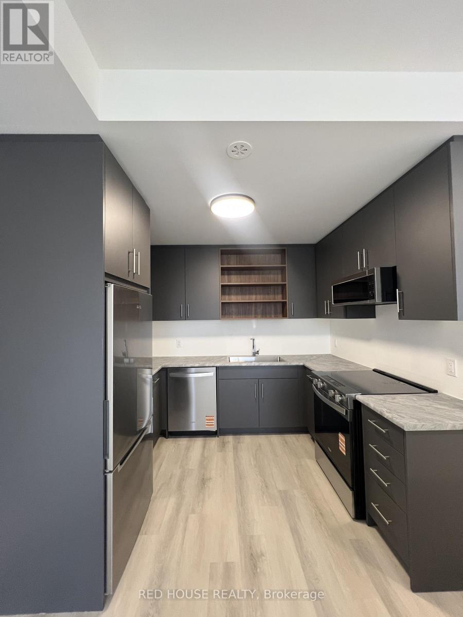 A modern kitchen with dark wood cabinets and stainless steel appliances.