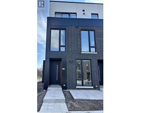 A modern house with a black front door and windows.