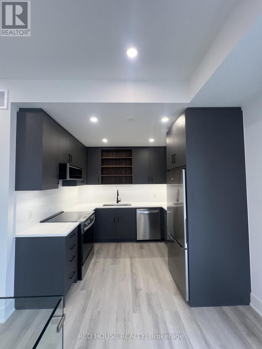 A modern kitchen with dark grey cabinets and a central island.