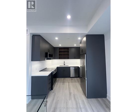 A modern kitchen with dark grey cabinets and a central island.