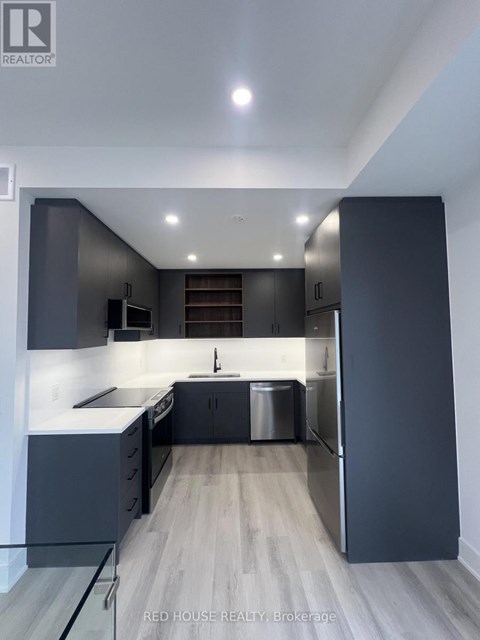 A modern kitchen with dark grey cabinets and a central island.