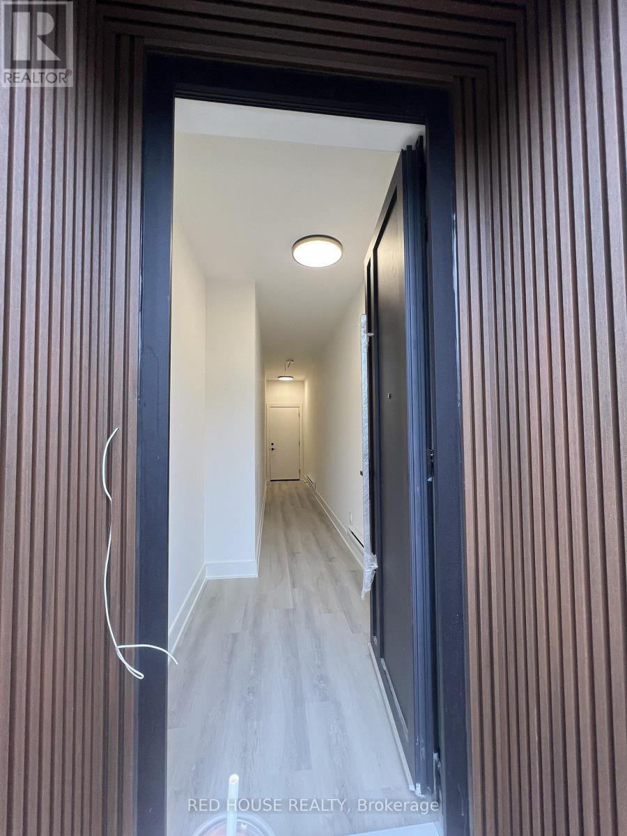 A hallway with a light on the ceiling and a door on the right.