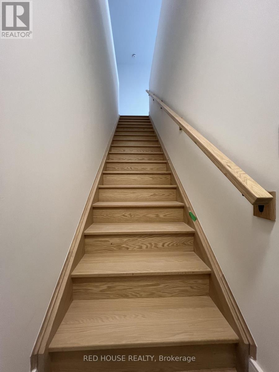 A set of wooden stairs with a handrail on the side.