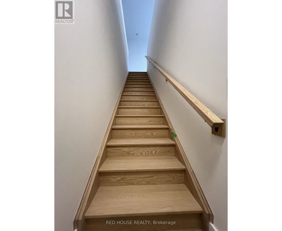 A set of wooden stairs with a handrail on the side.
