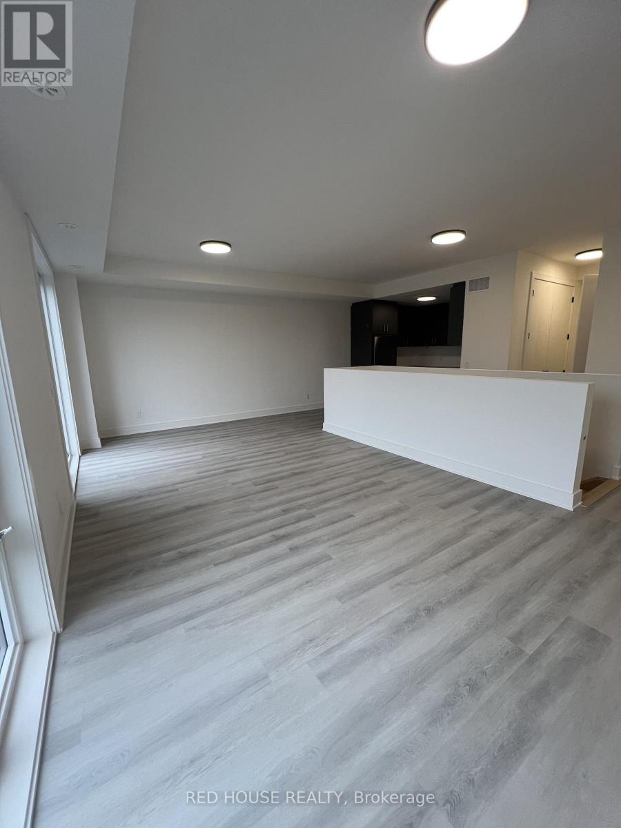 A spacious room with a white wall and a grey floor.