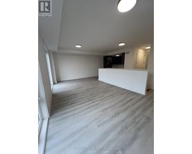 A spacious room with a white wall and a grey floor.