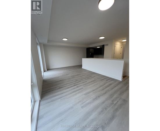 A spacious room with a white wall and a grey floor.