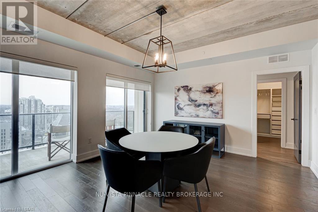 A dining room with a table and chairs and a view of the city.