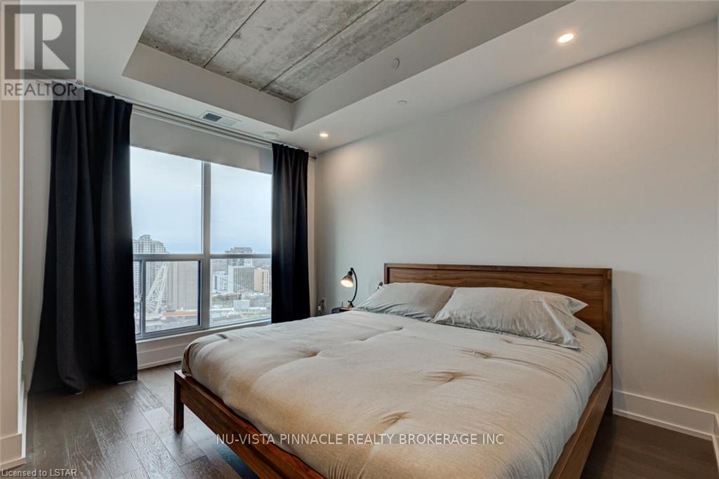 A bedroom with a large bed and a view of the city.