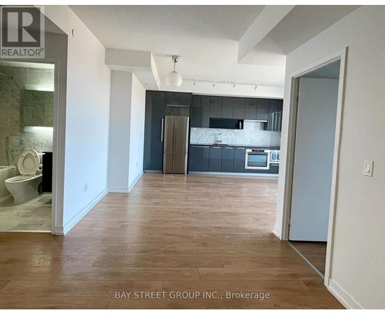A realtor photo of a kitchen and living room with wood floors.