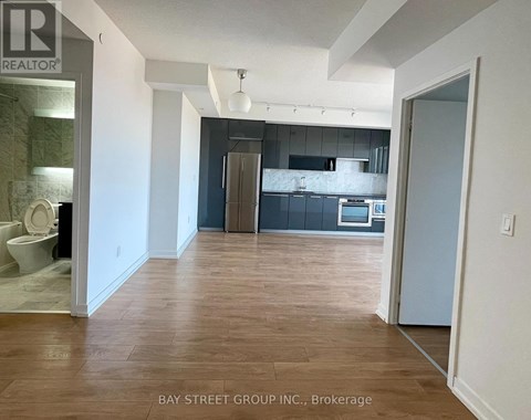 A realtor photo of a kitchen and living room with wood floors.