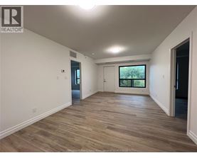 A spacious room with wooden flooring and white walls.