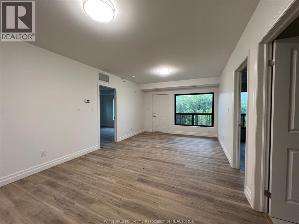 A spacious room with wooden flooring and white walls.