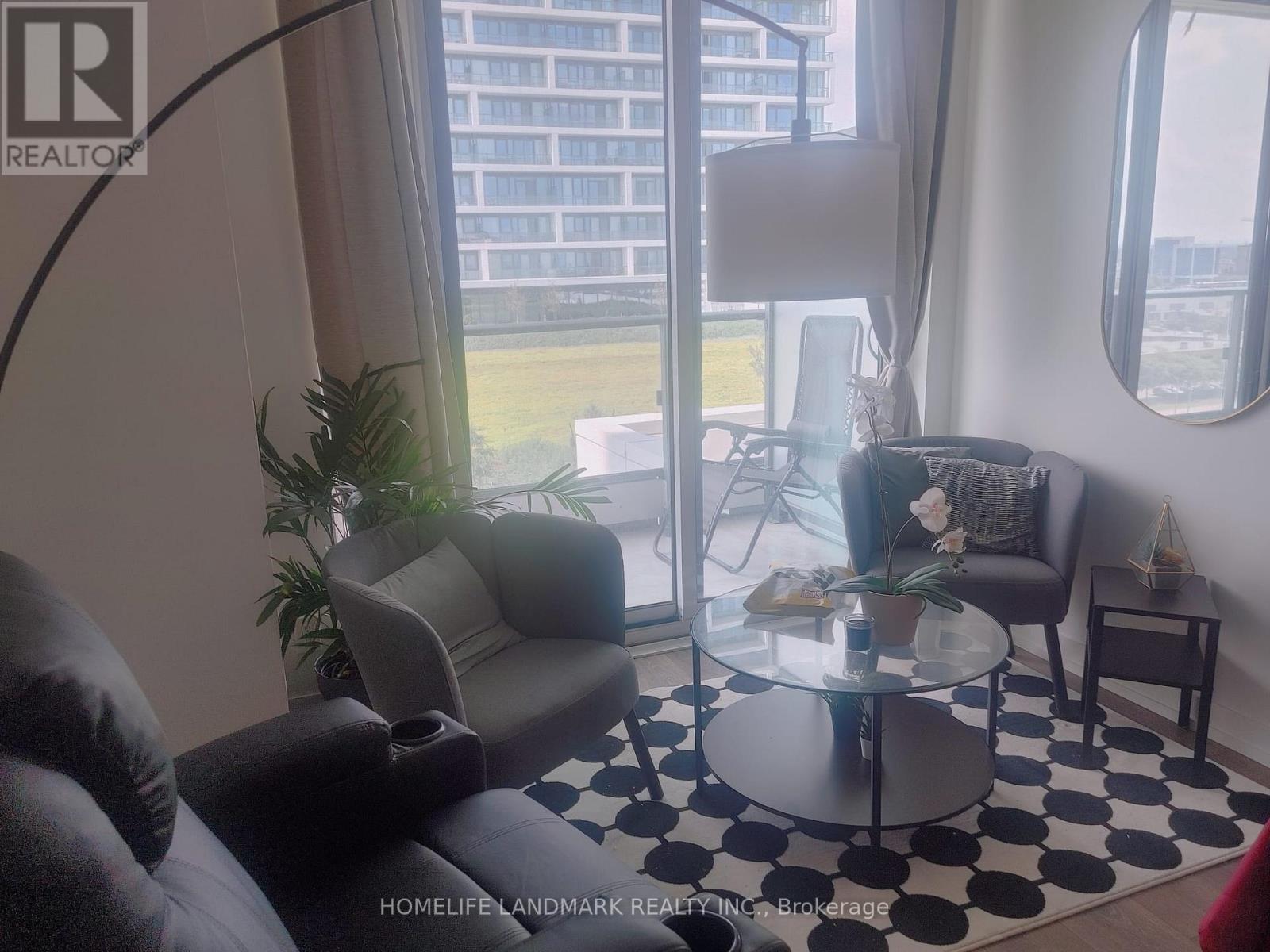 A living room with a glass table and a black and white checkered rug.