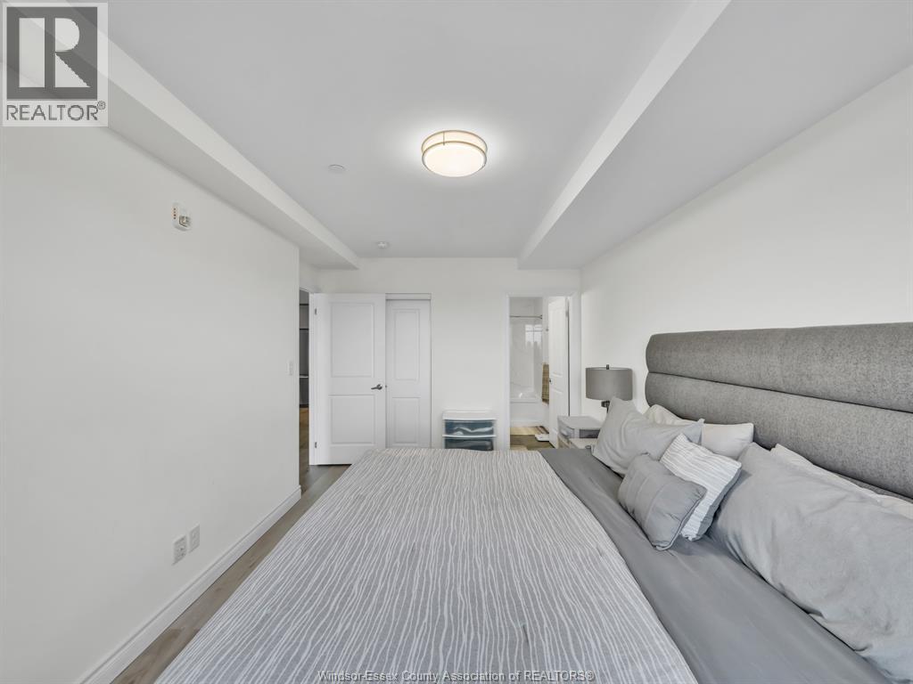 A bedroom with a bed and a striped carpet.