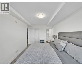 A bedroom with a bed and a striped carpet.