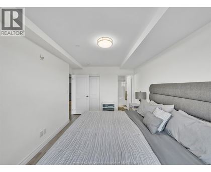 A bedroom with a bed and a striped carpet.