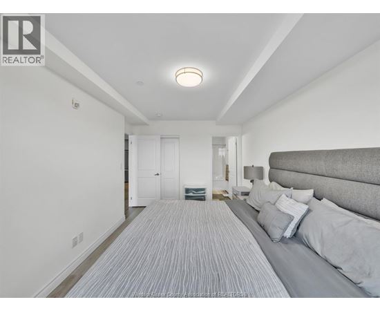 A bedroom with a bed and a striped carpet.