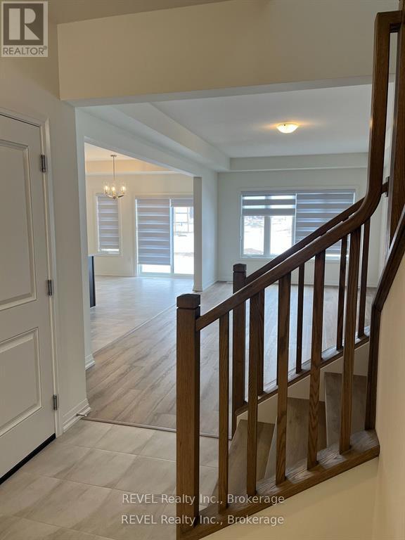 A staircase in a home with a white door and a window with blinds.