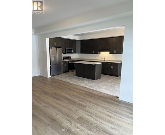 A kitchen with dark wood cabinets and a light wood floor.