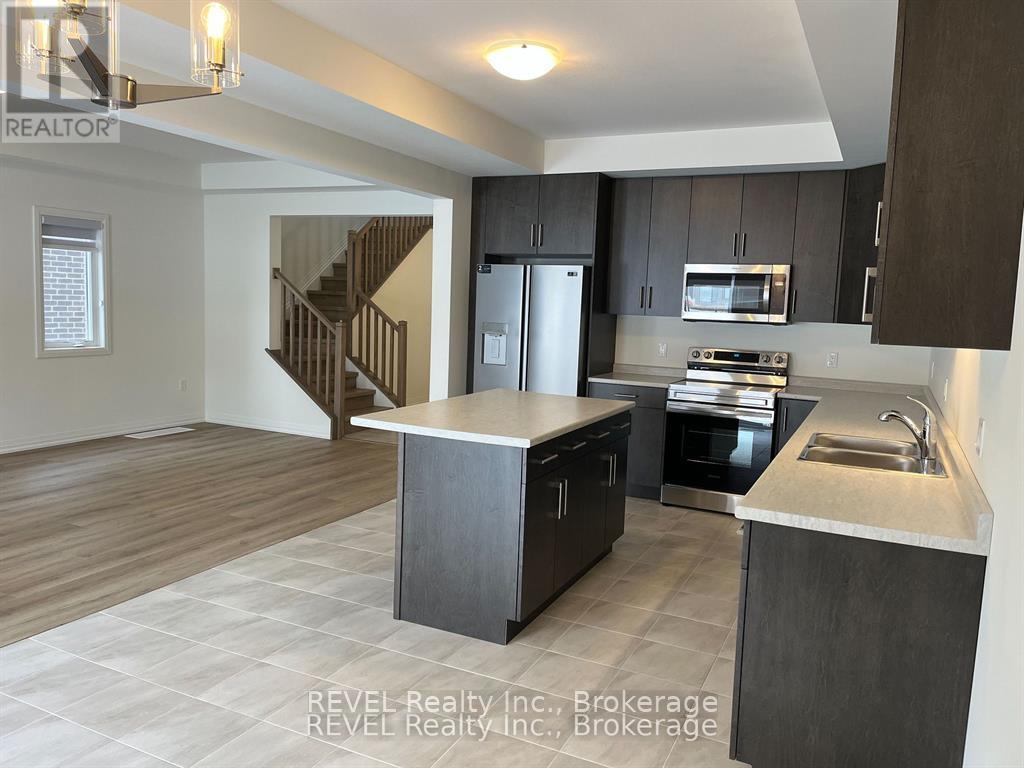 A modern kitchen with dark wood cabinets and stainless steel appliances.