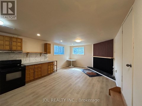 A spacious kitchen with wooden cabinets and a black stove top oven.