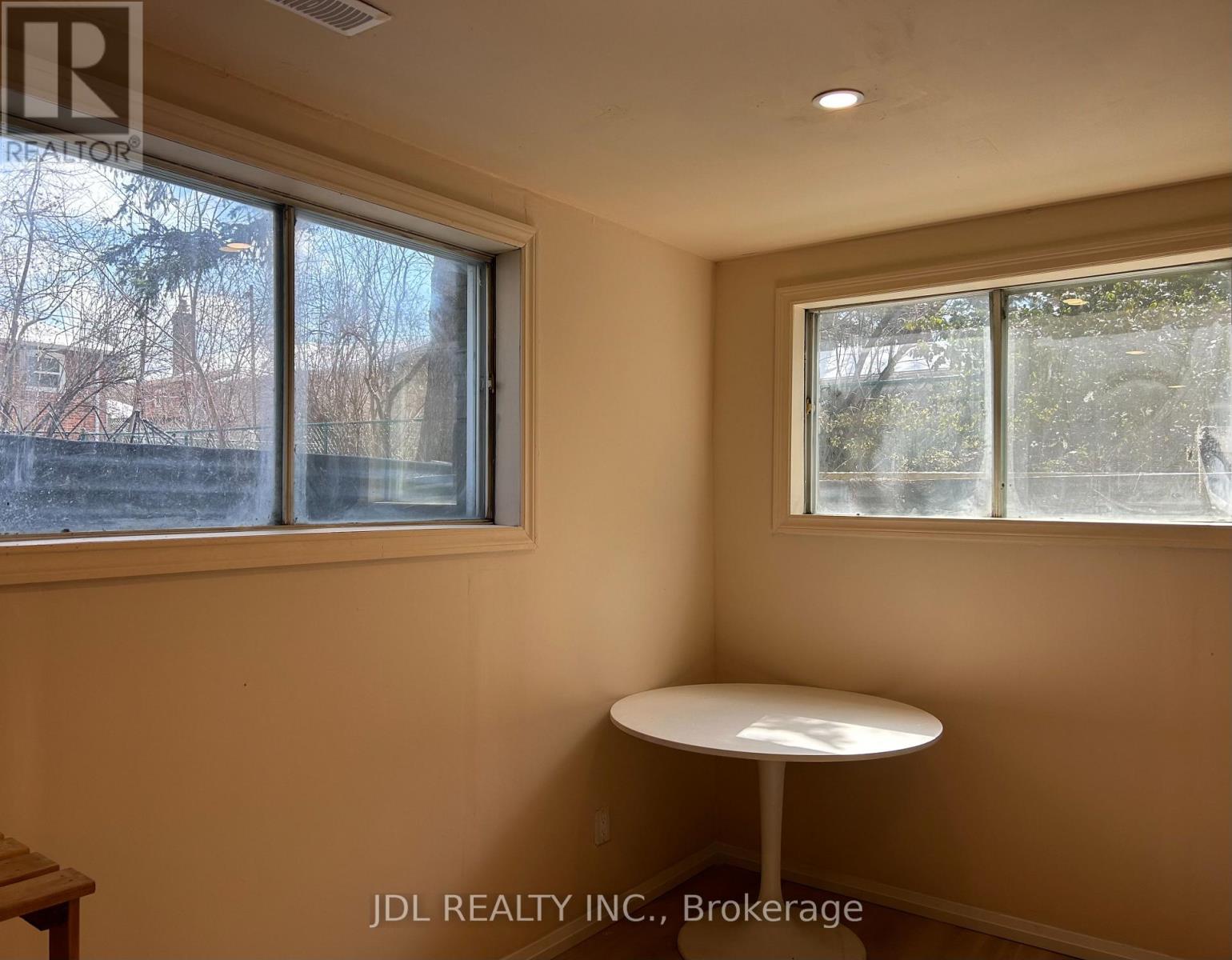 A room with a table and two windows.