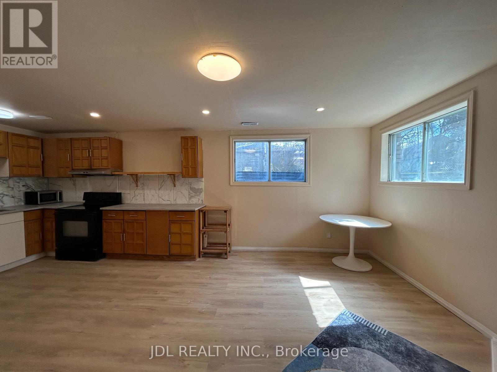 A kitchen with wooden cabinets and a black stove top oven.