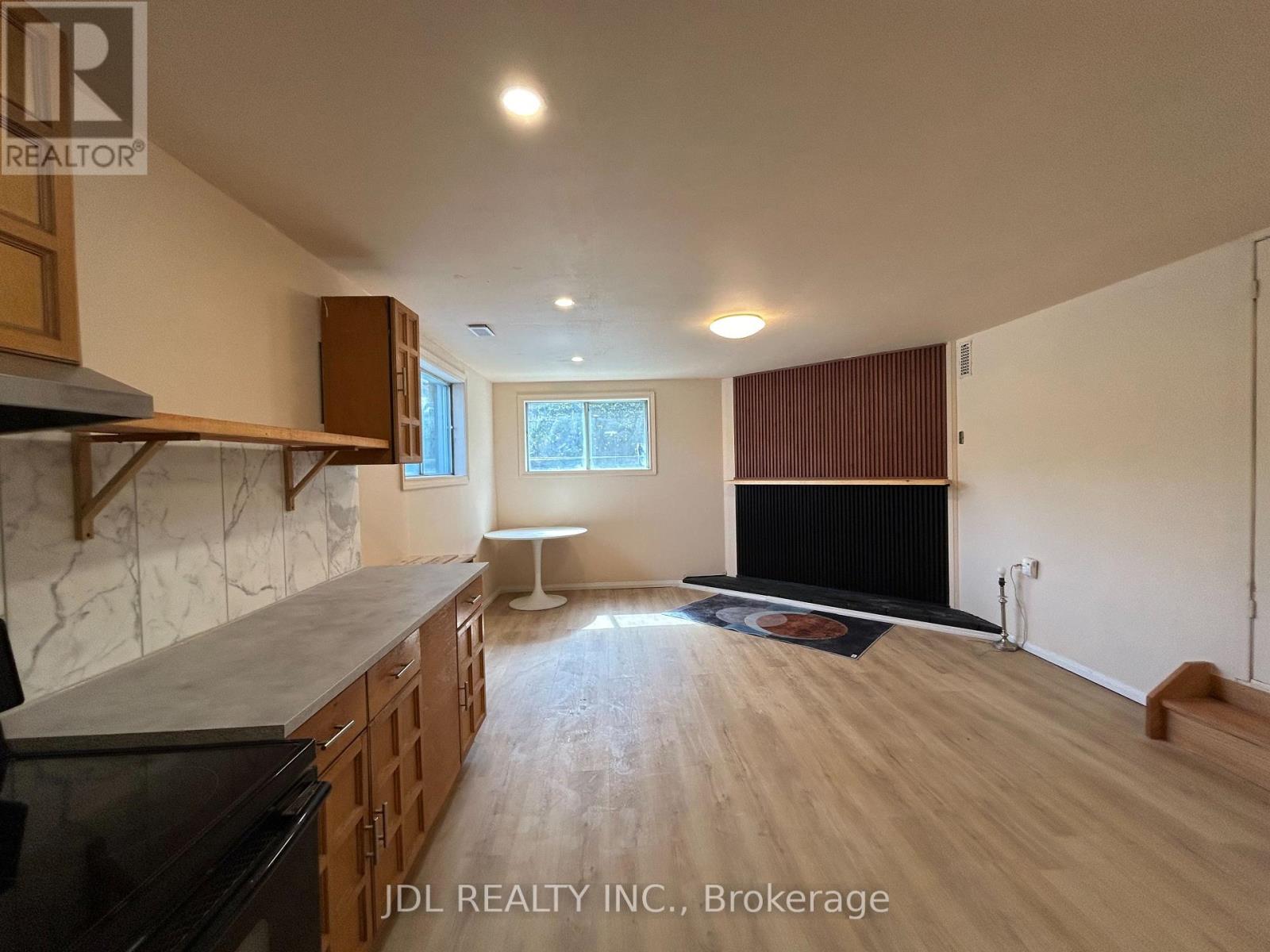 A spacious living room with wooden floors and a fireplace.