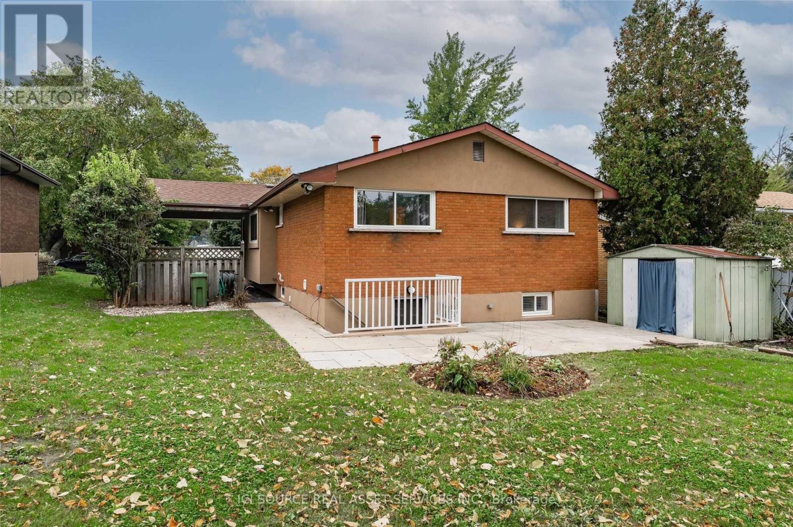 A house with a brown brick exterior and a white fence.