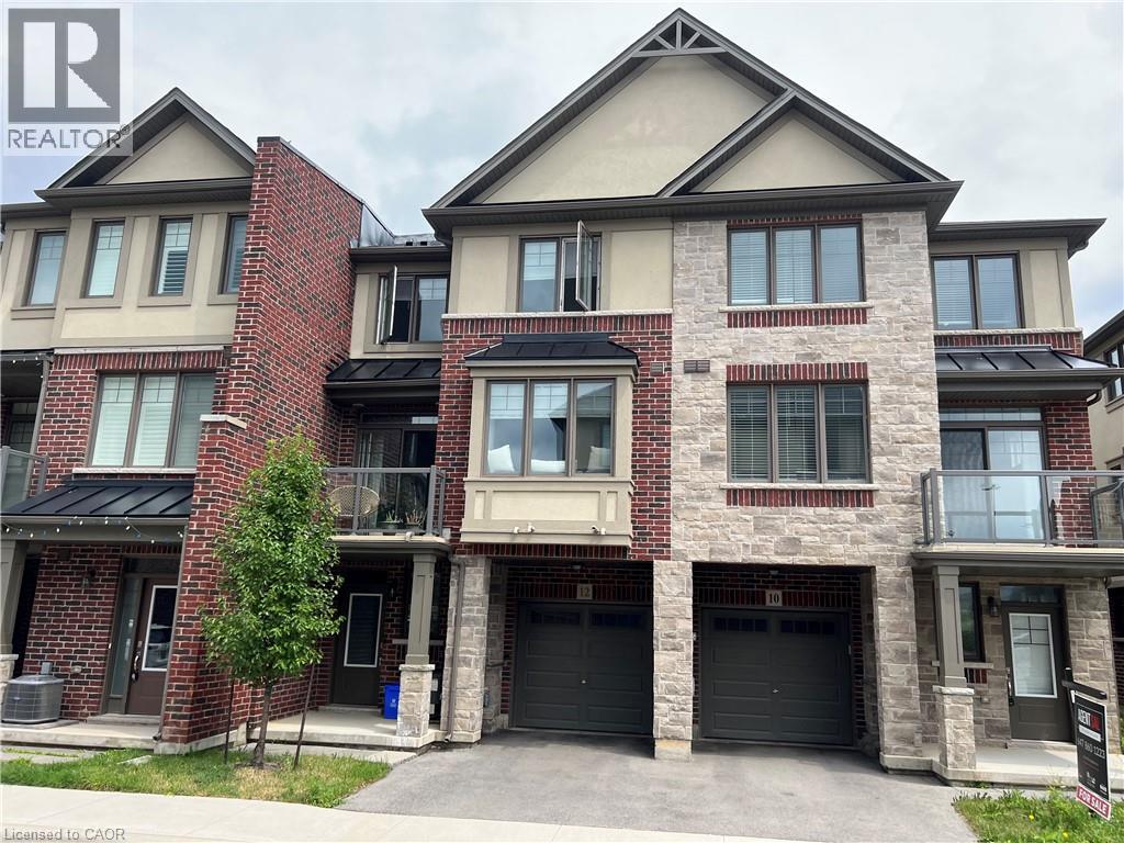 A large, multi-story residential building with a brick facade and multiple garage doors.
