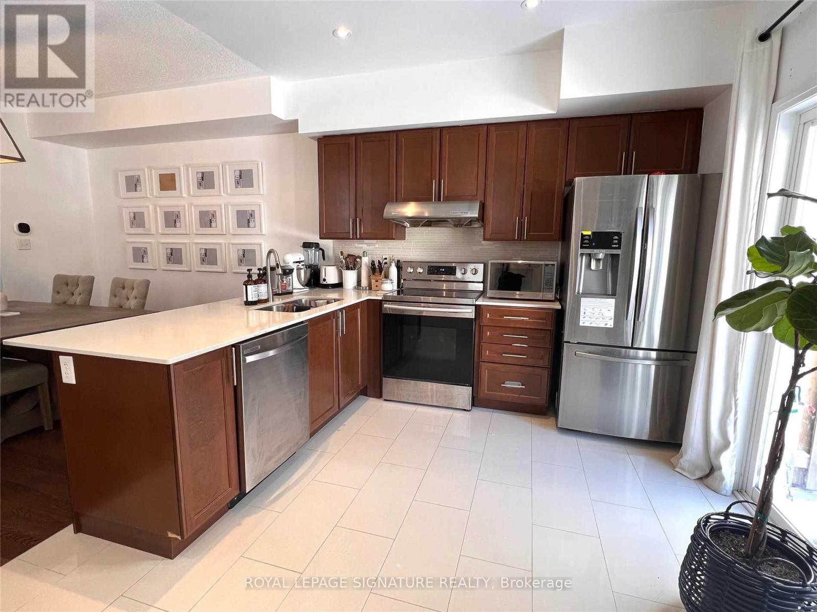 A kitchen with brown cabinets and stainless steel appliances.