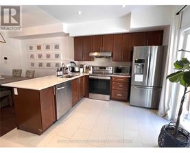 A kitchen with brown cabinets and stainless steel appliances.