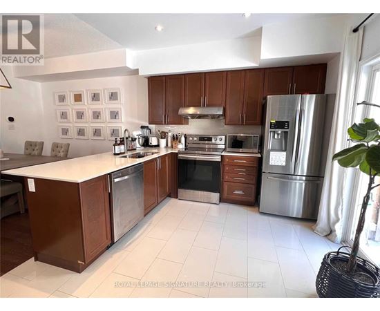A kitchen with brown cabinets and stainless steel appliances.