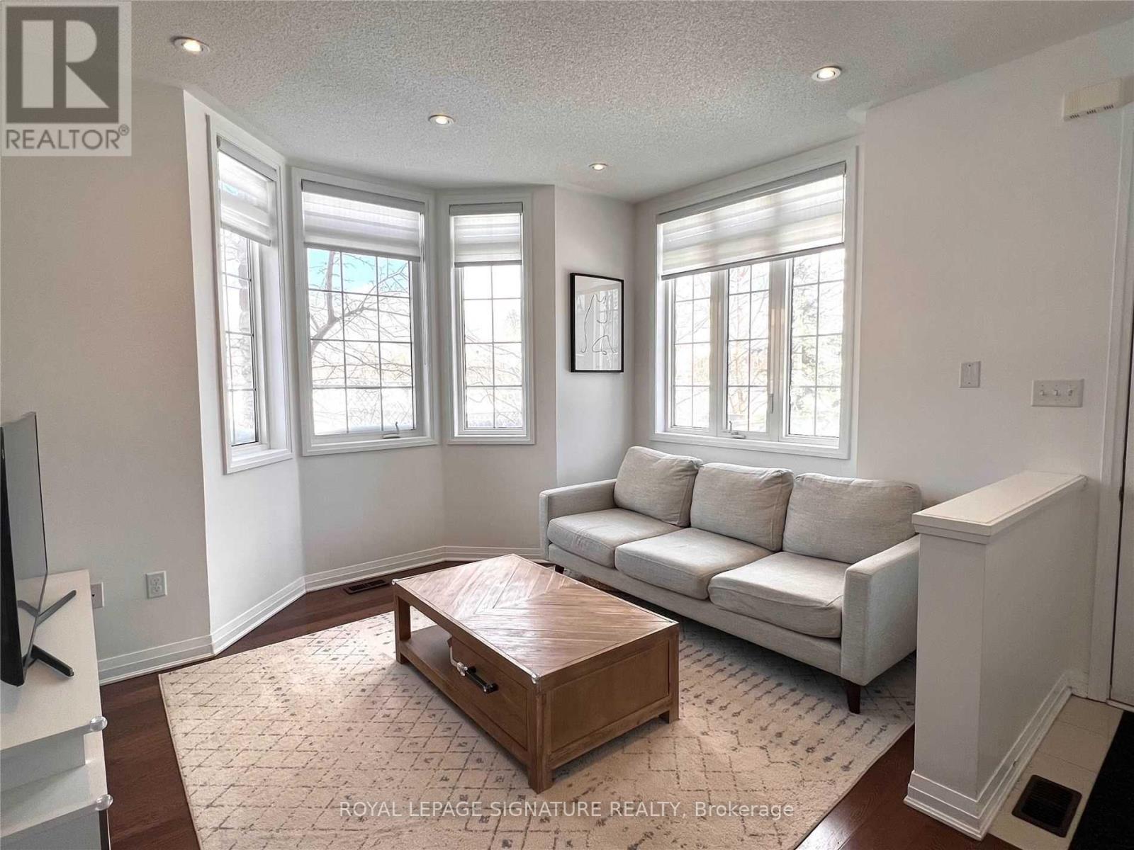 A living room with a white couch and a wooden coffee table.