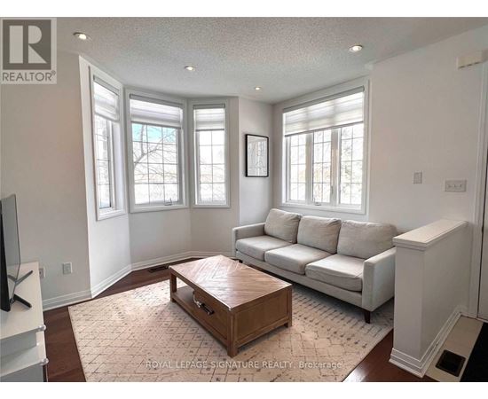 A living room with a white couch and a wooden coffee table.