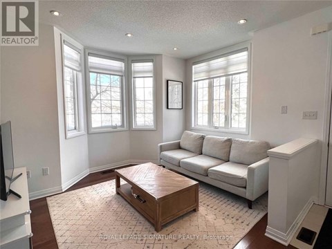 A living room with a white couch and a wooden coffee table.