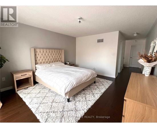 A bedroom with a large bed and a wooden dresser.