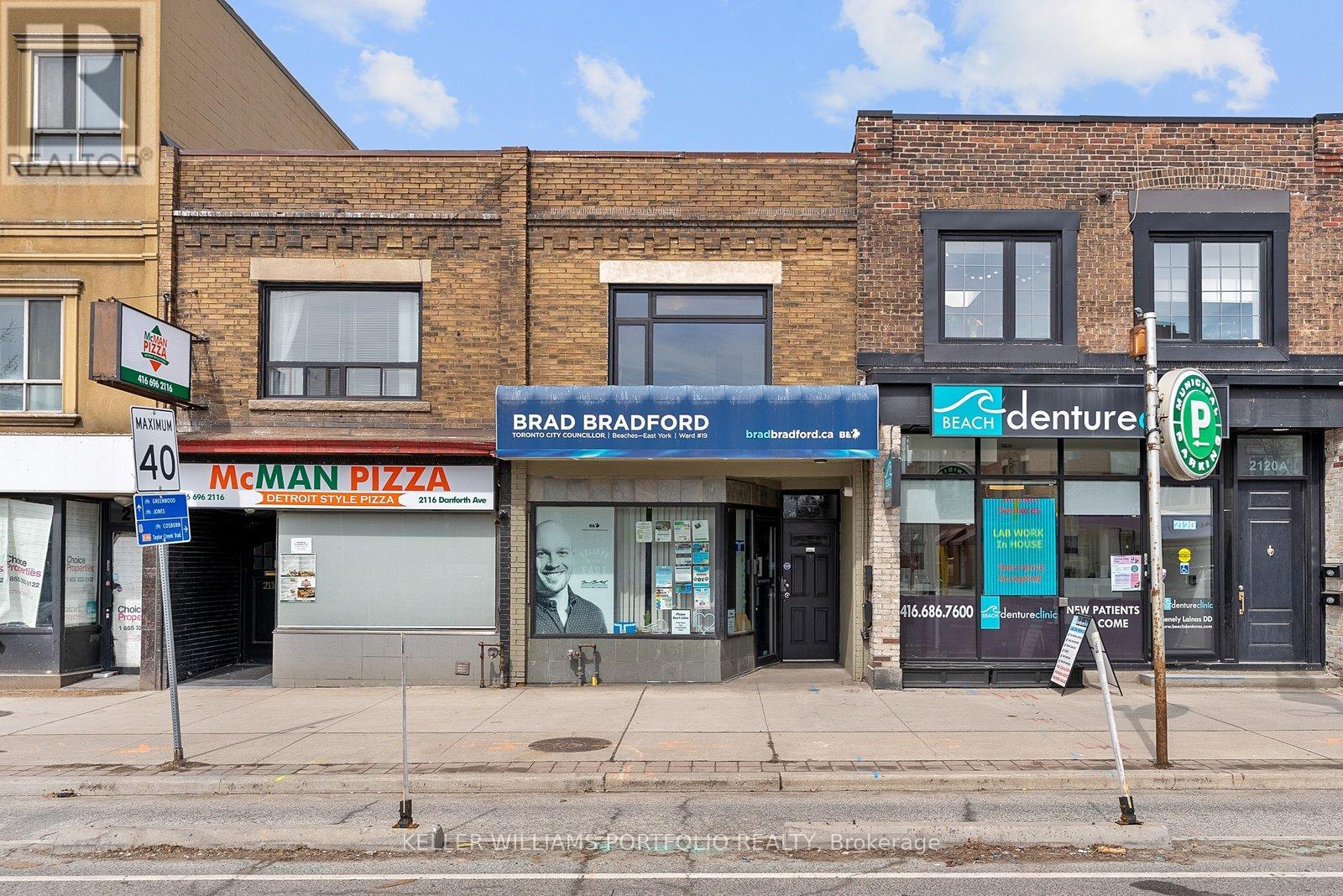 A street view of a building with a sign that says "McMAN PIZZA".