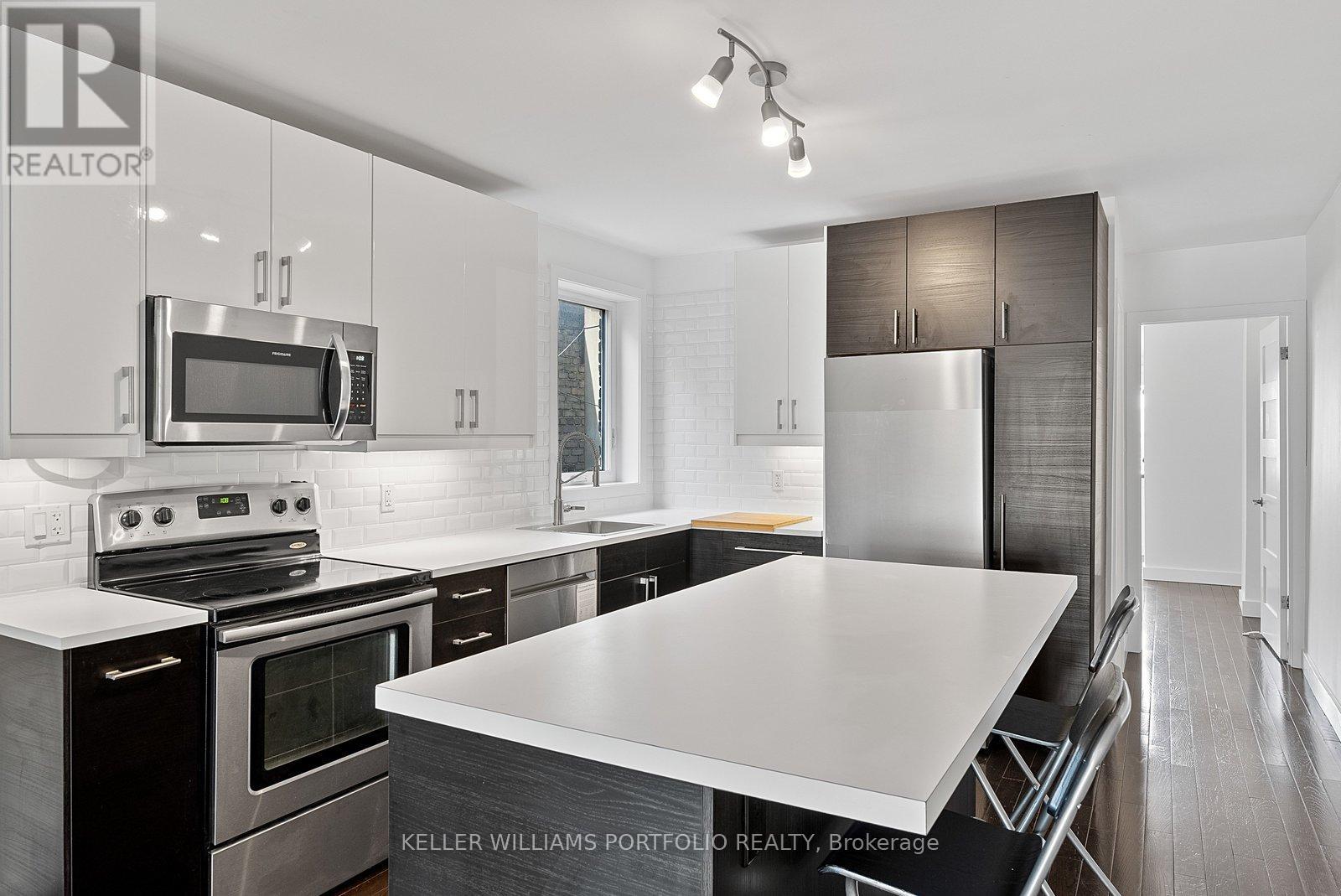 A modern kitchen with a stove top oven and microwave above it.