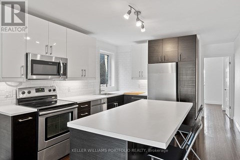 A modern kitchen with a stove top oven and microwave above it.