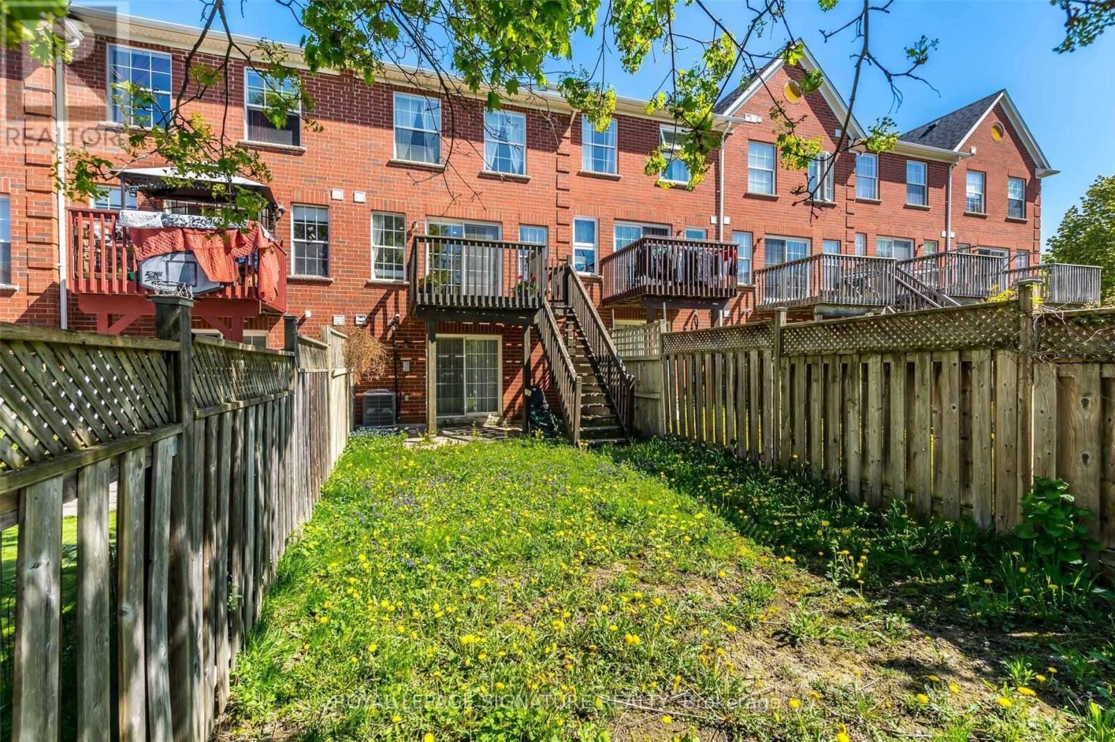 A red brick building with a wooden fence in front.
