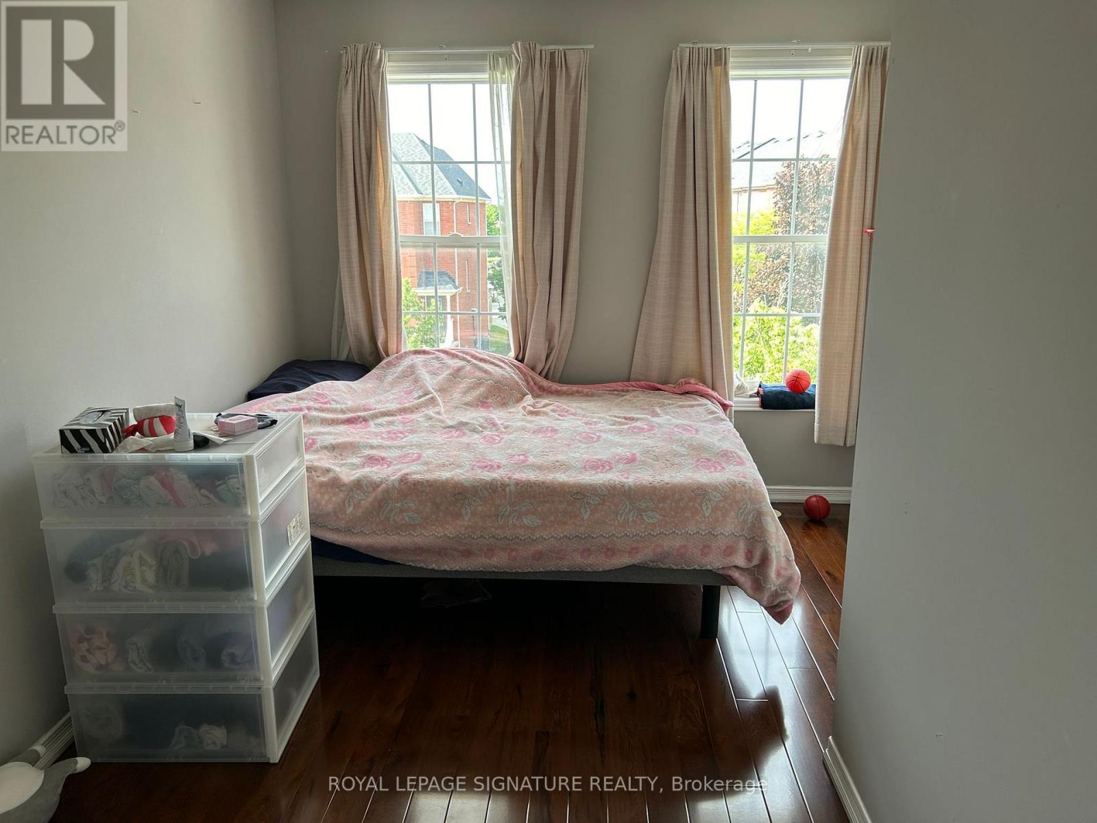 A bedroom with a bed, dresser, and window.