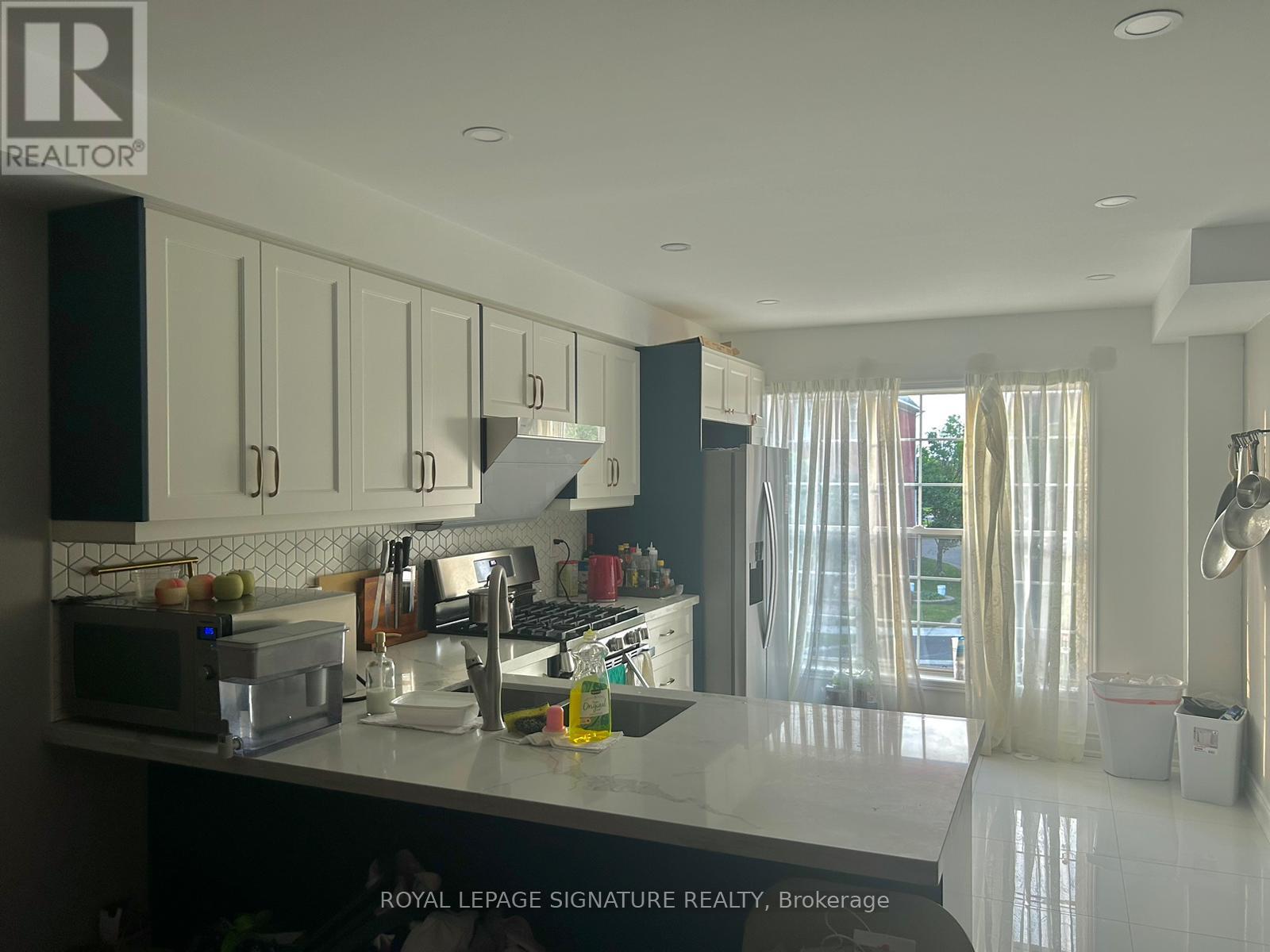 A kitchen with white cabinets and a microwave.