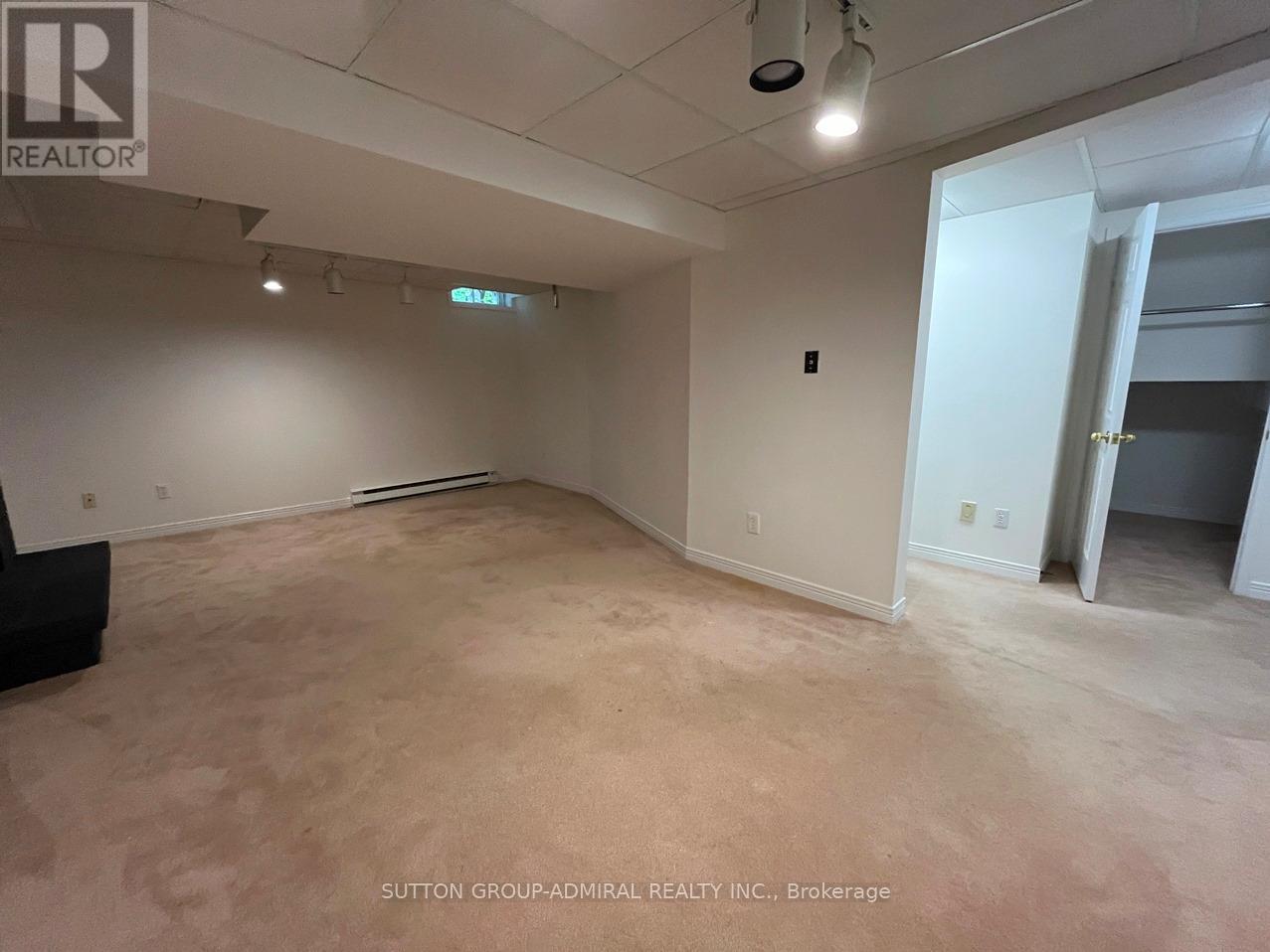 A spacious room with a carpeted floor and a door on the right side.