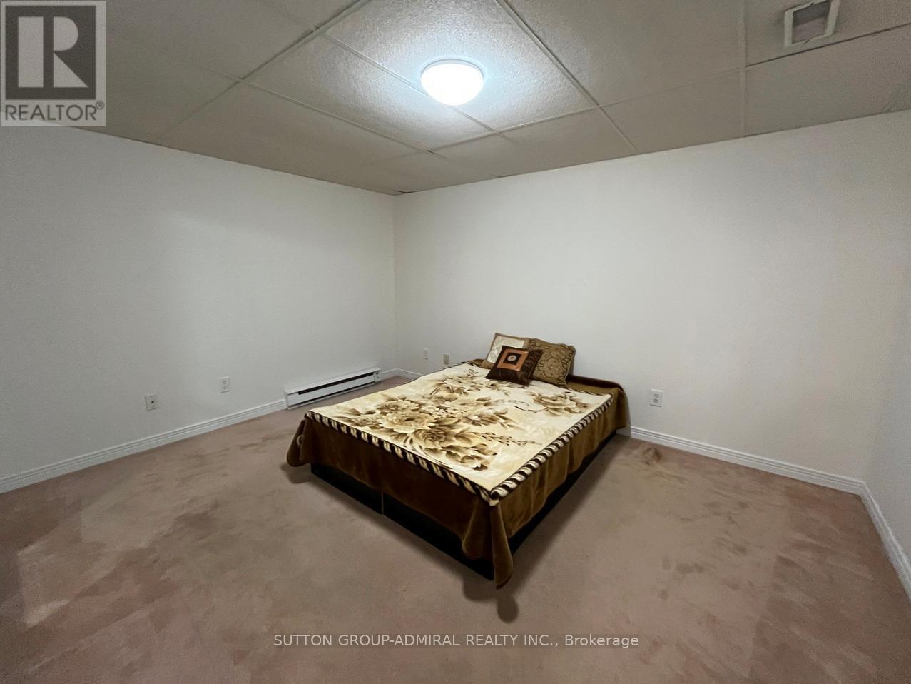 A bedroom with a bed and a ceiling light.