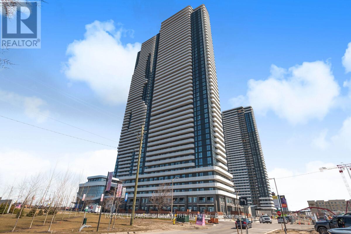 A tall building with a striped facade is under construction with a blue sky in the background.