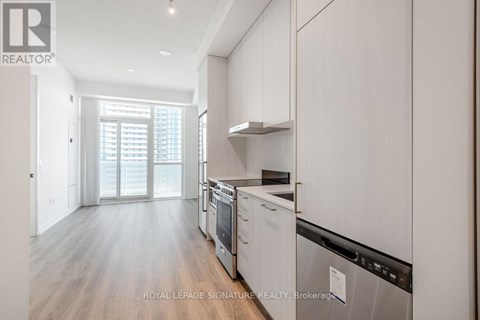 A modern kitchen with white cabinets and stainless steel appliances.
