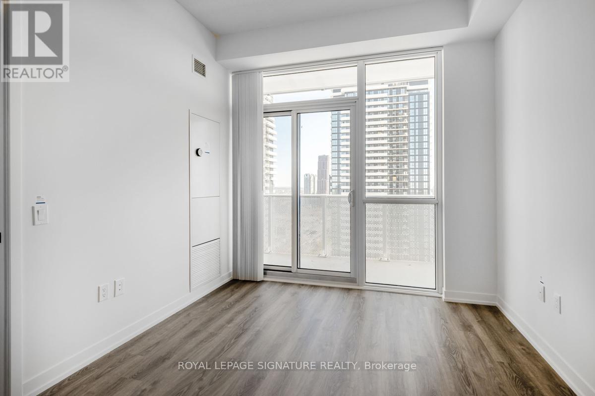 A room with a sliding glass door leading to a balcony.