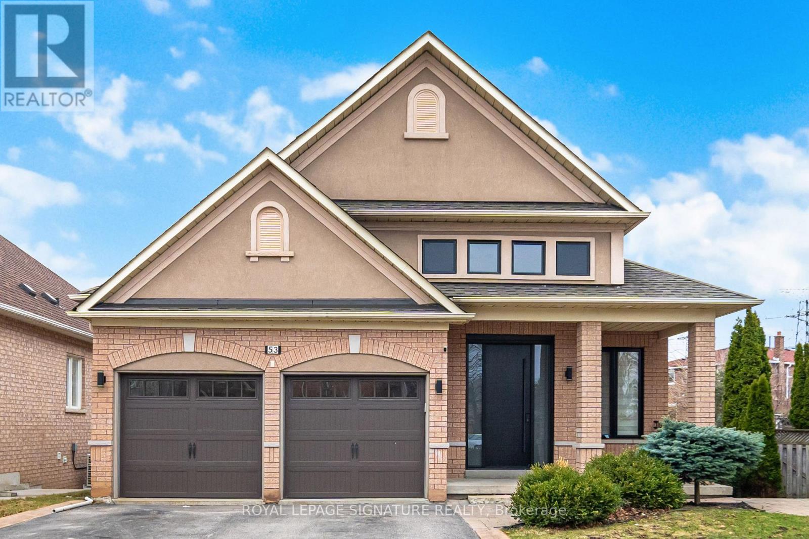 A two-story house with a garage and a driveway.